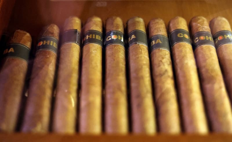 A row of cigars in a wooden box